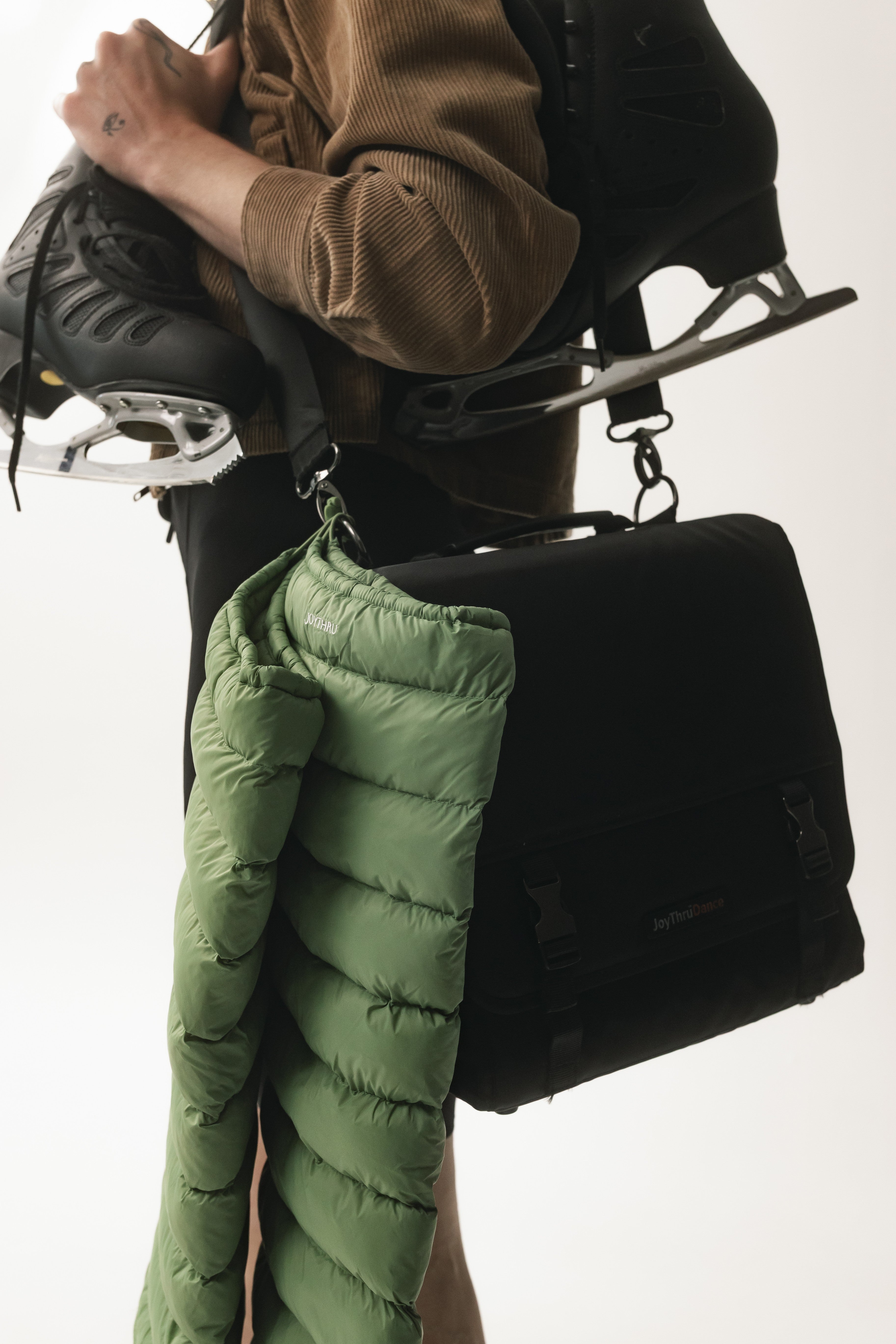 Sage LegPuffs hanging from the JoyThru Dance Bag beside ice skates