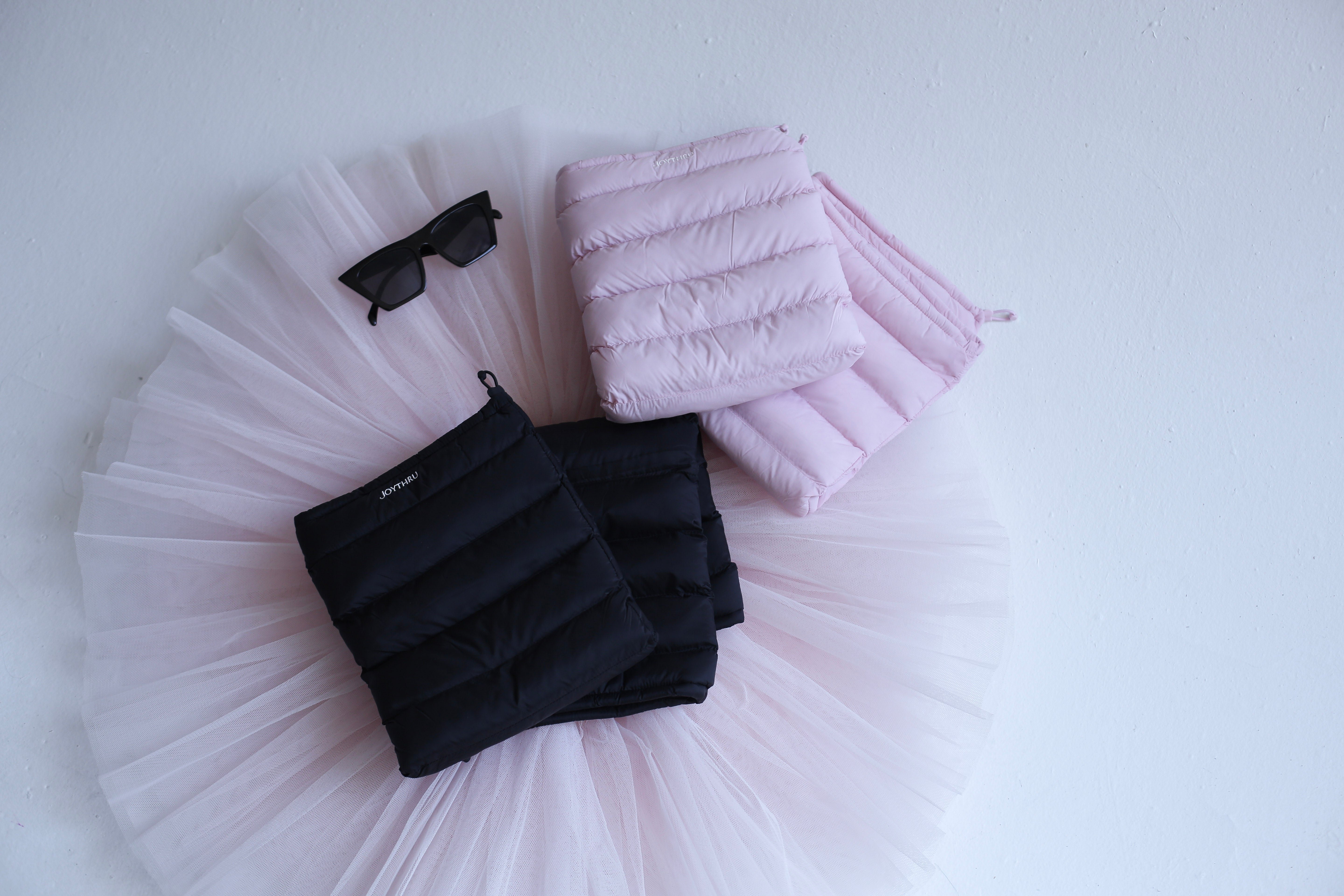Classic Harmony bundle: Onyx and Blush LegPuffs folded on a tutu, flatlay