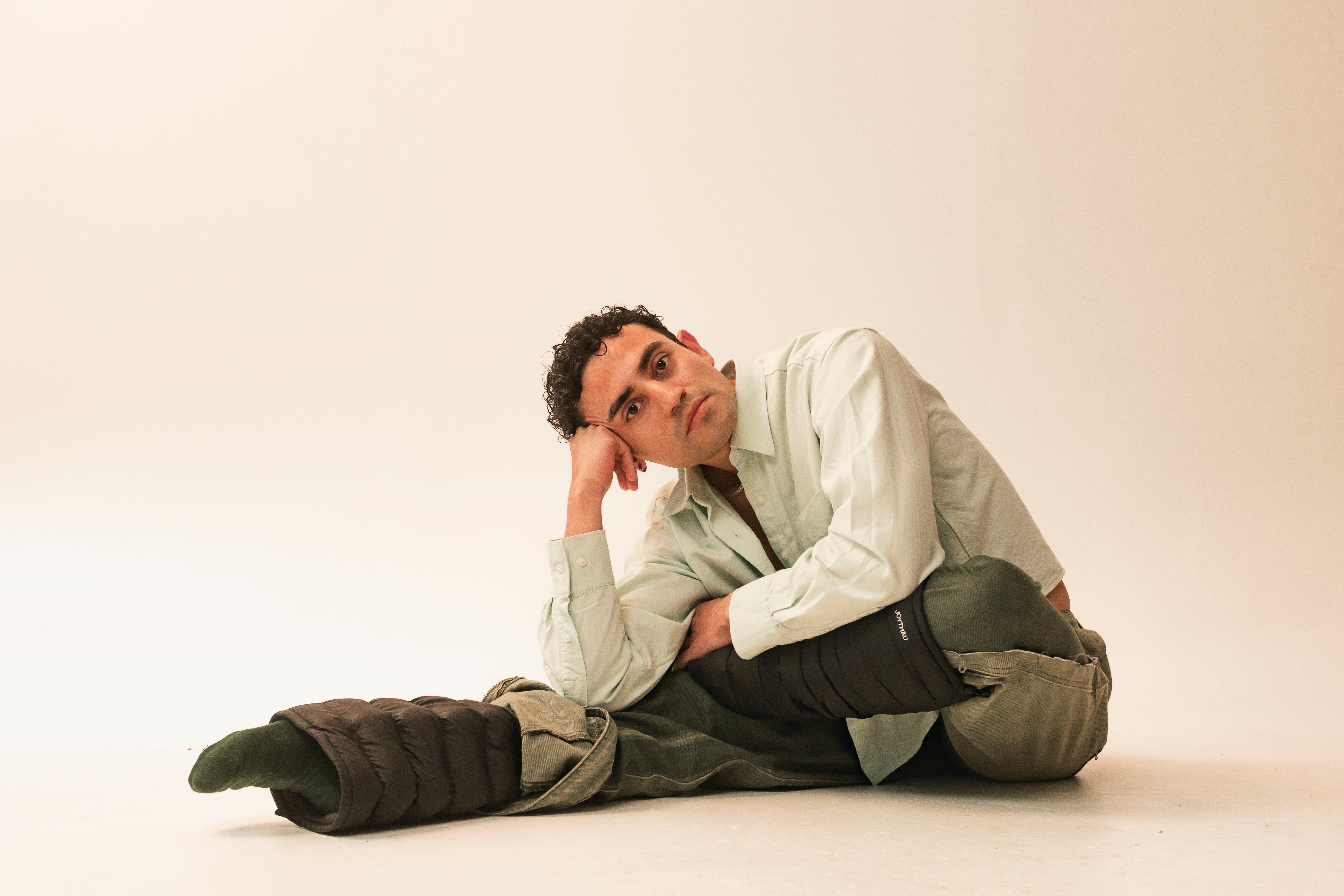 Miguel resting on Onyx LegPuffs, warm studio backdrop