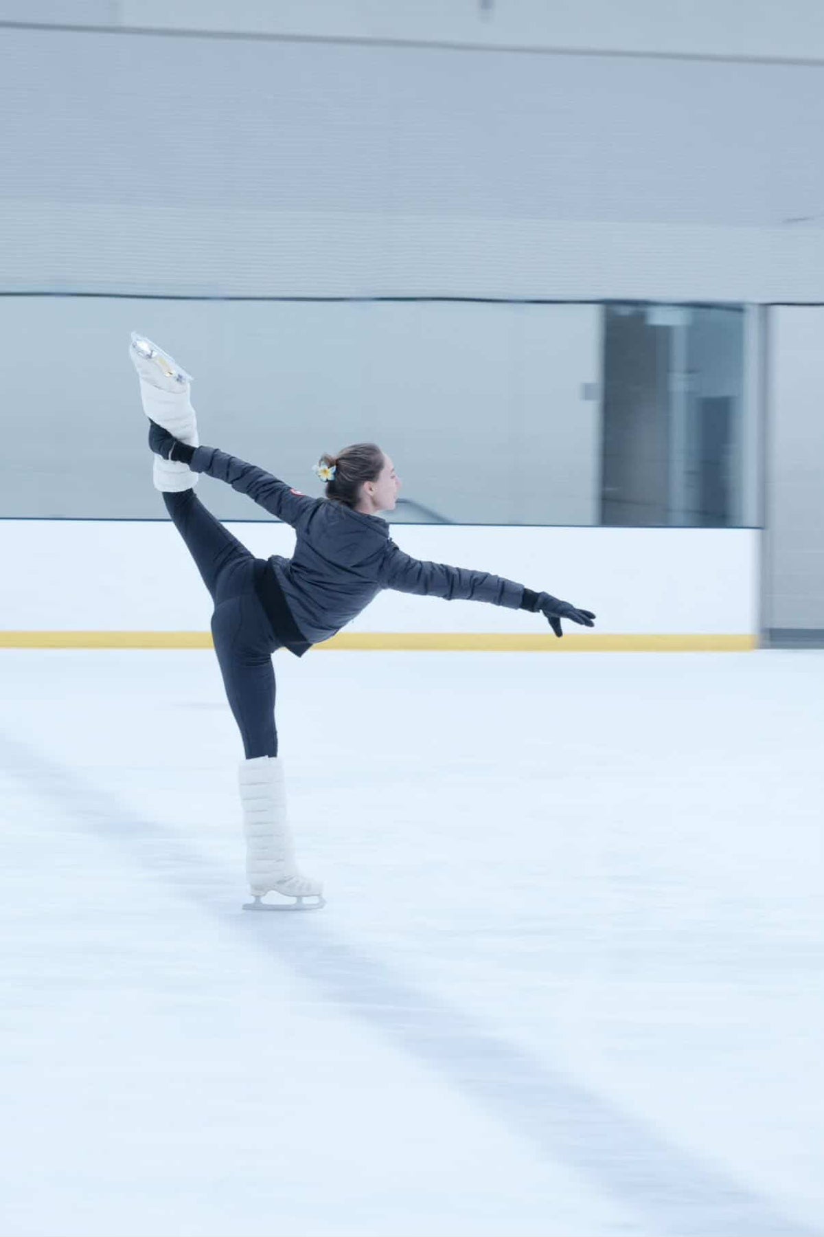 Figure skater gliding in a spiral wearing Frost LegPuffs