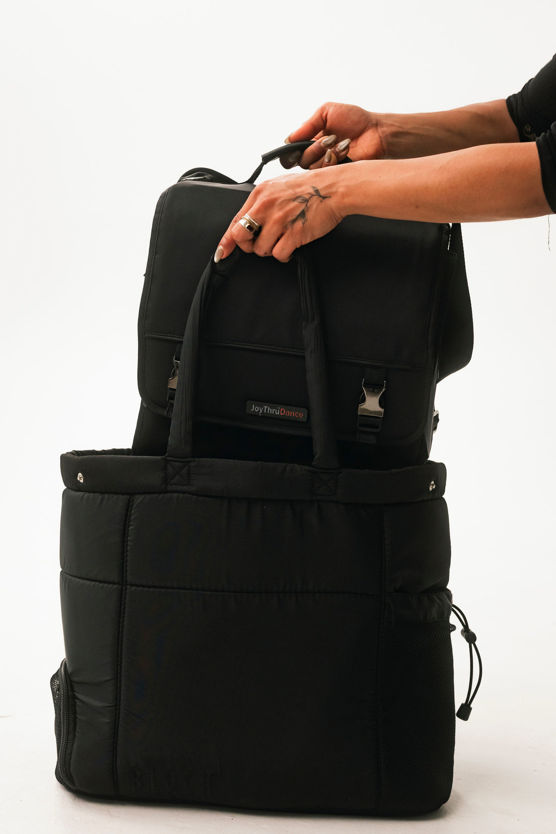 Hands closing the JoyThru Dance Bag Organizer, buckle detail