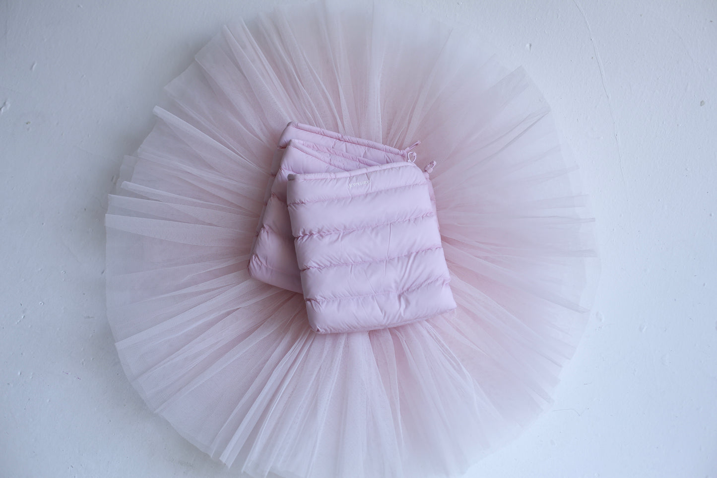 Blush LegPuffs folded on a blush tutu, flatlay on white