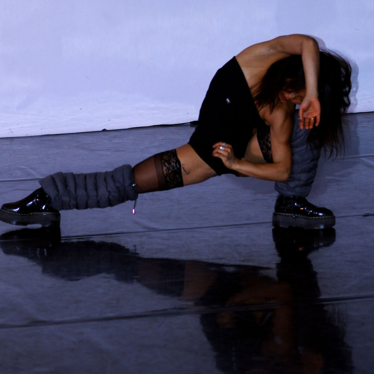 Dancer in a floor pose wearing Charcoal LegPuffs