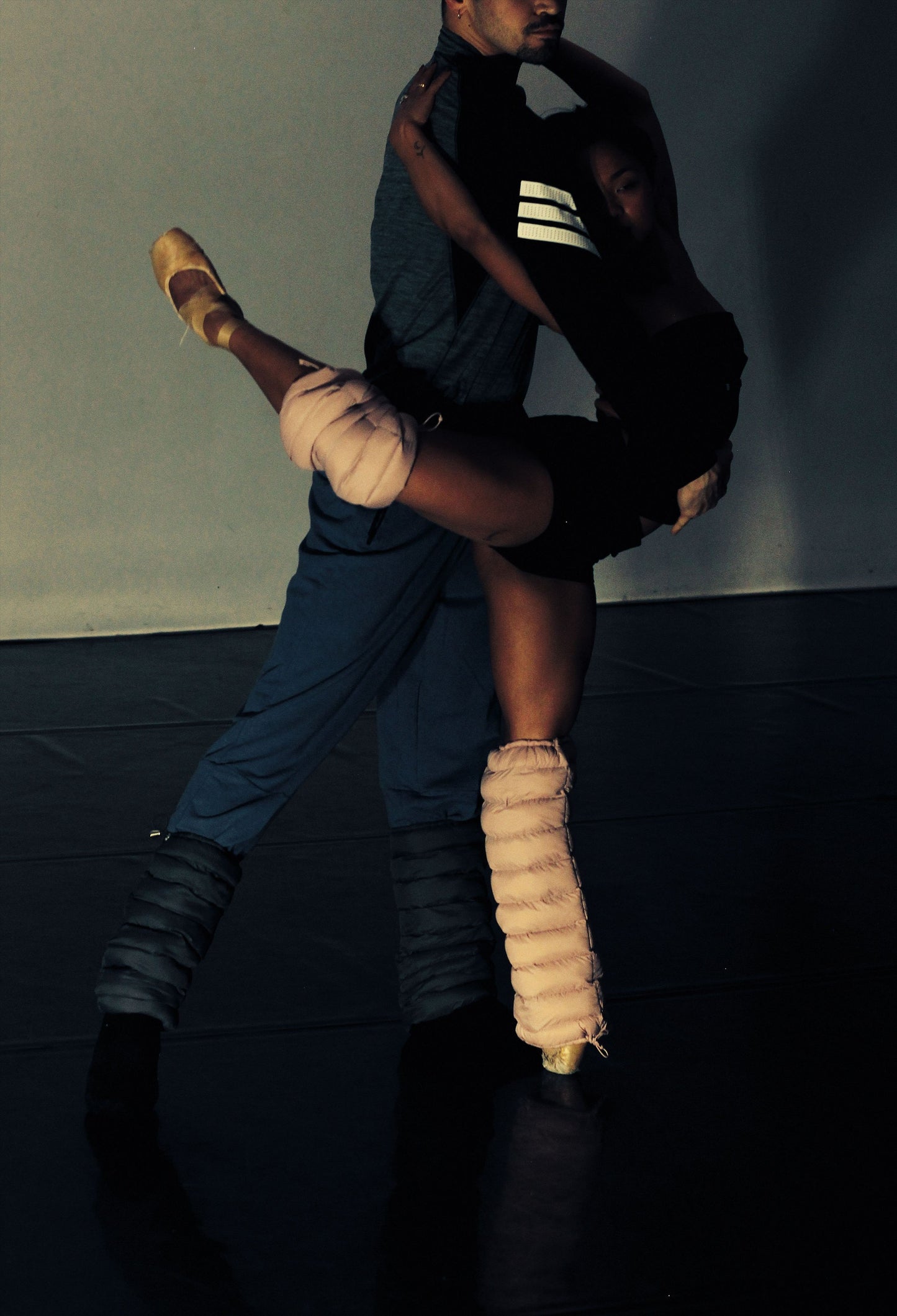 Dancers partnering on a dark stage, wearing blush LegPuffs