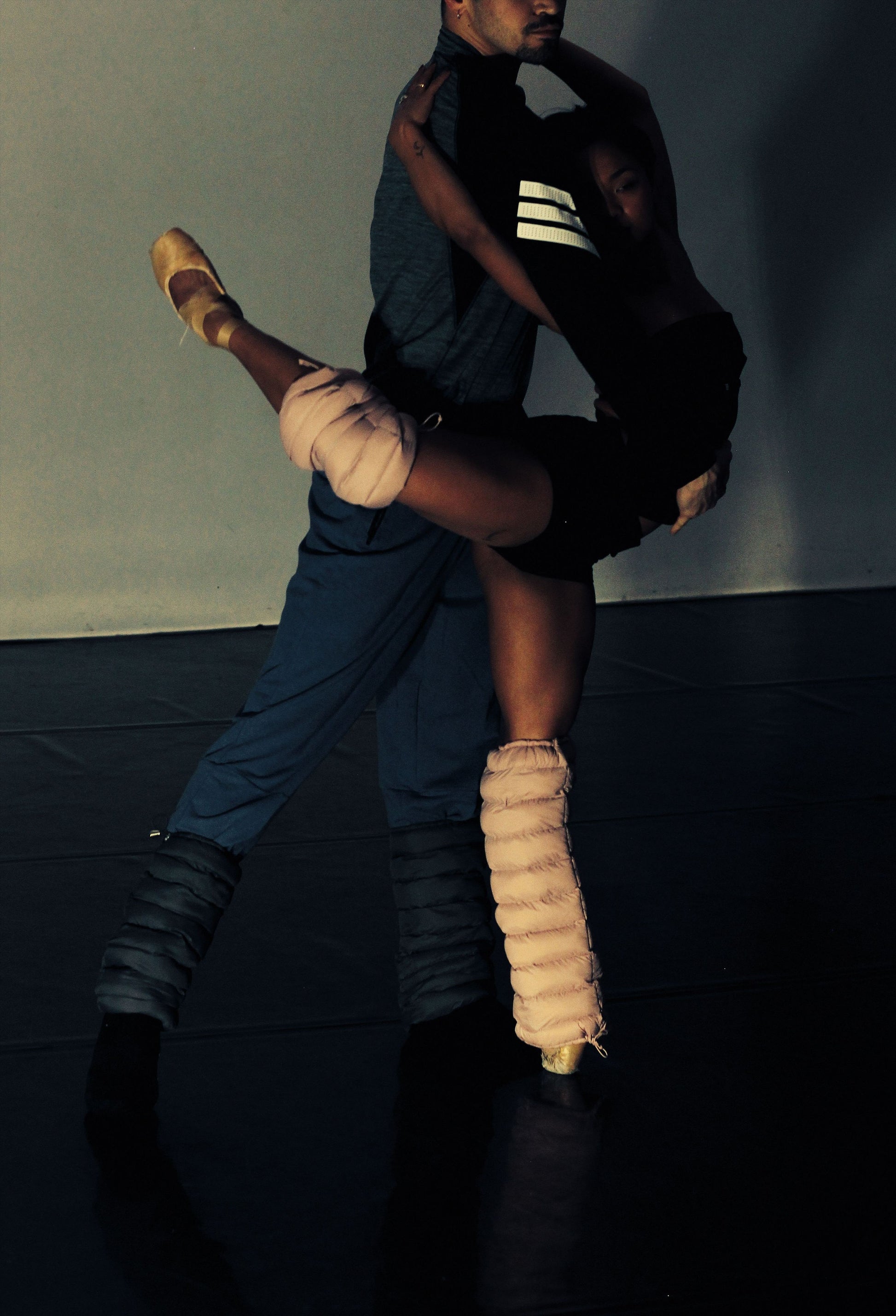 Dancers partnering on a dark stage, wearing blush LegPuffs