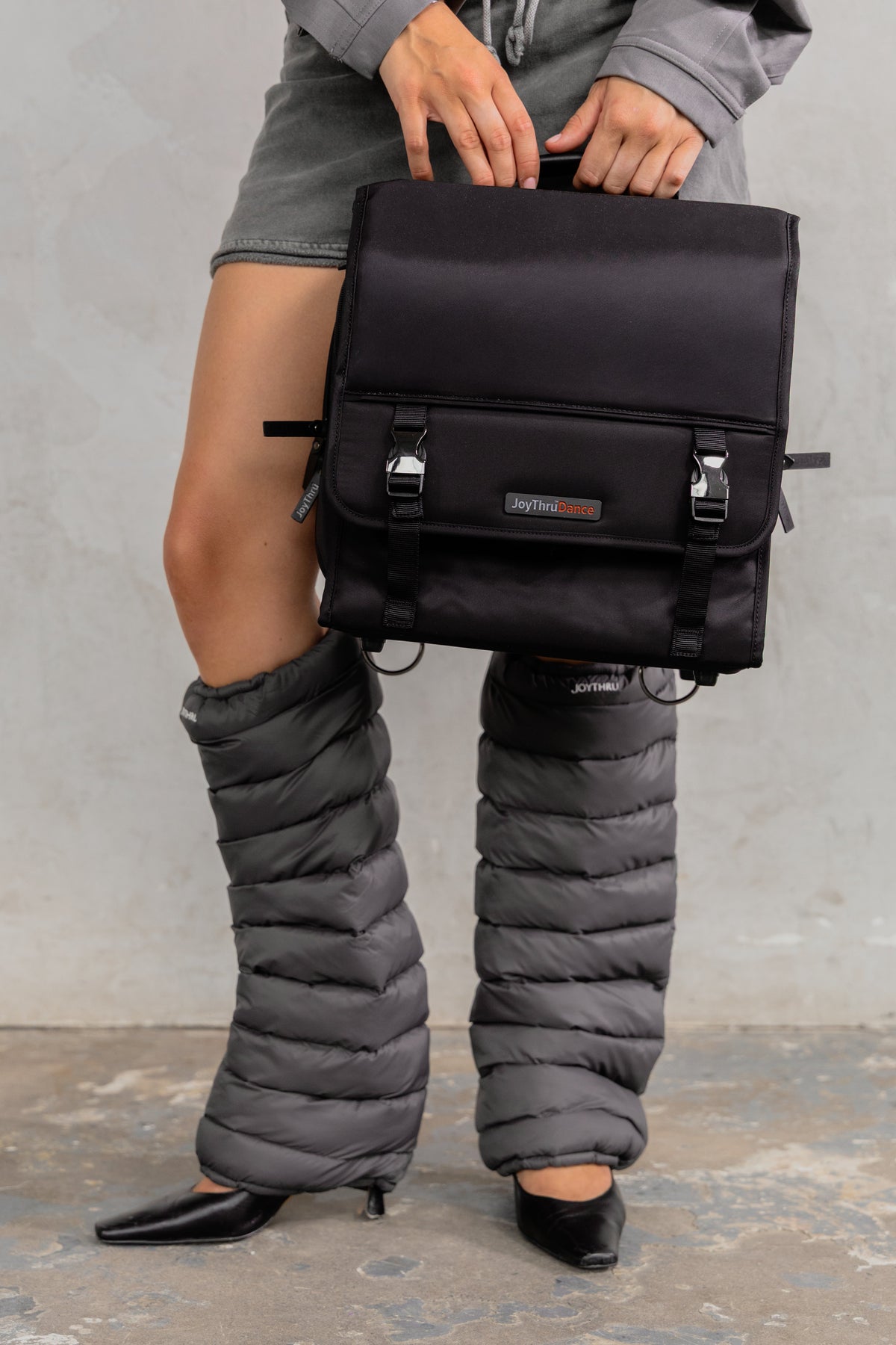 Model holding the JoyThru Gear Organizer, wearing Charcoal LegPuffs