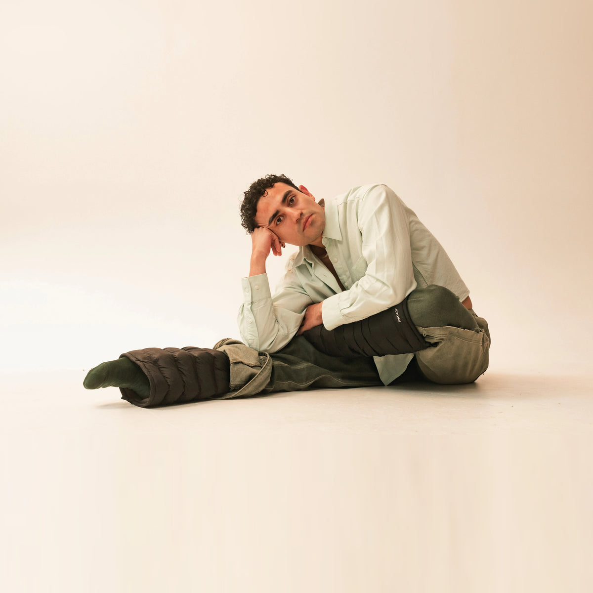 Miguel resting on Onyx LegPuffs, warm studio backdrop